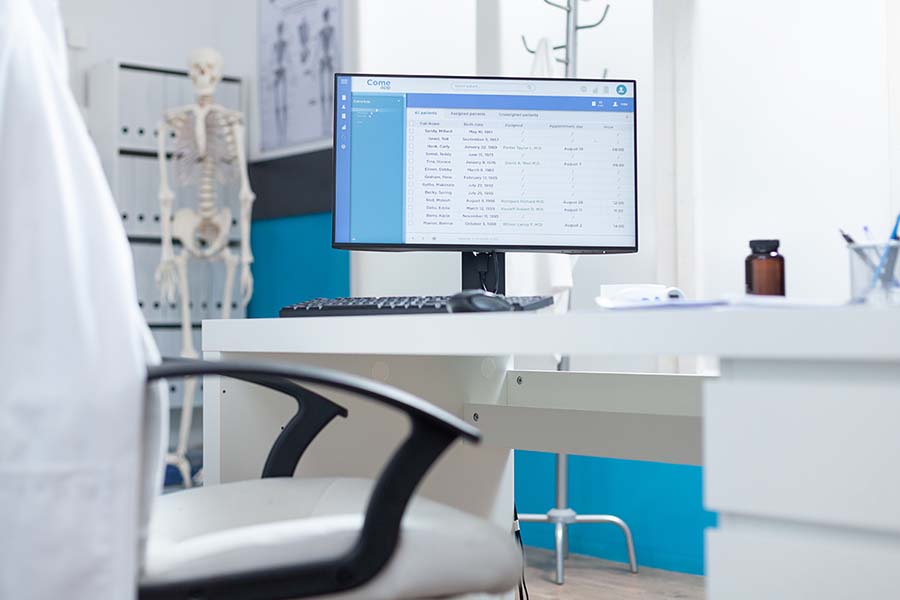 Computer with medical patient files on screen standing on table