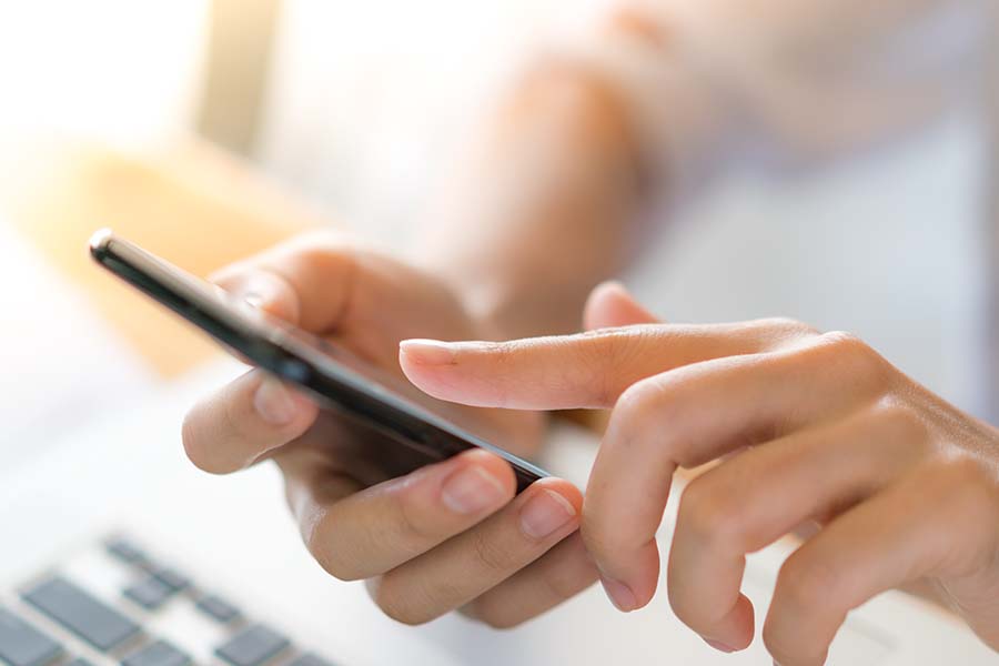 Business woman hand with Financial charts and mobile phone over